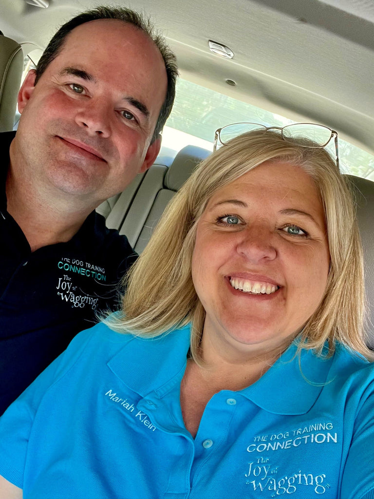 Owners Mariah and Eric of Joy of Wagging smile in a vehicle.