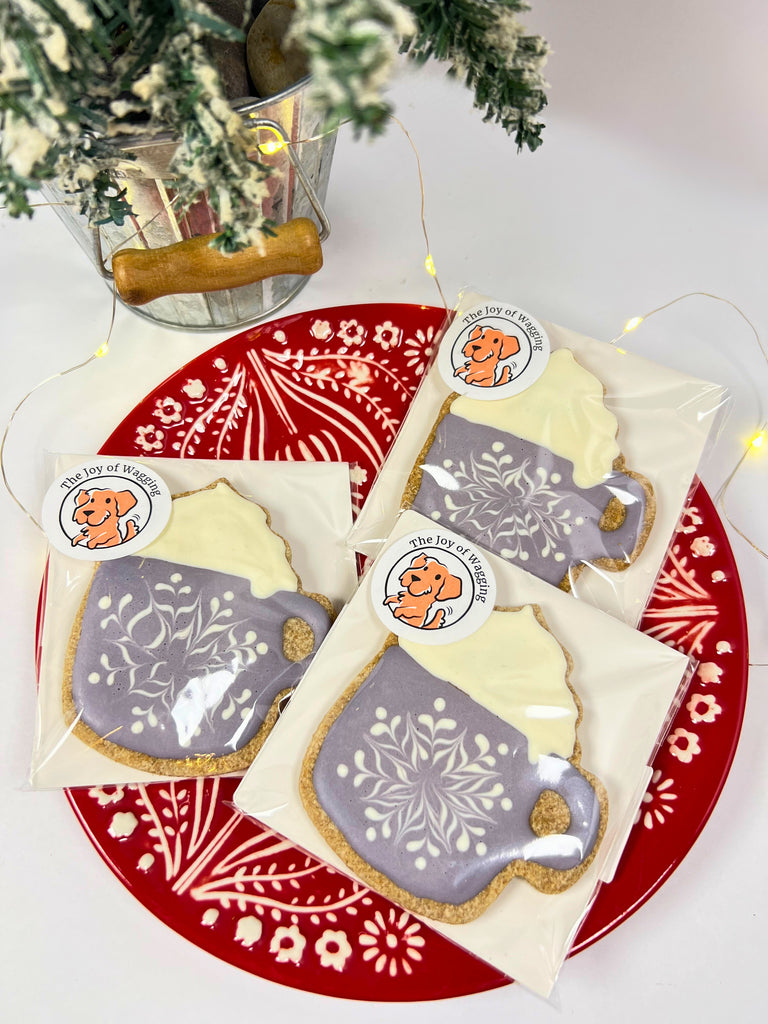 Decorative cookies with festive designs on a red plate with white patterns.