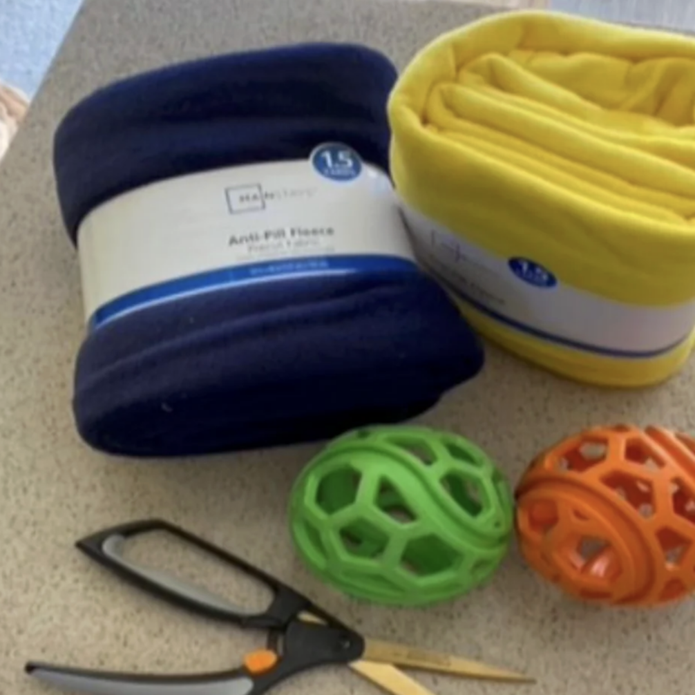 fleece fabric, rubber balls, and scissors to make a fleece tug toy for dogs